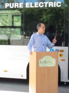 Jerry Tinianow standing at a LaQuinta Inn & Suites podium speaking about sustainability